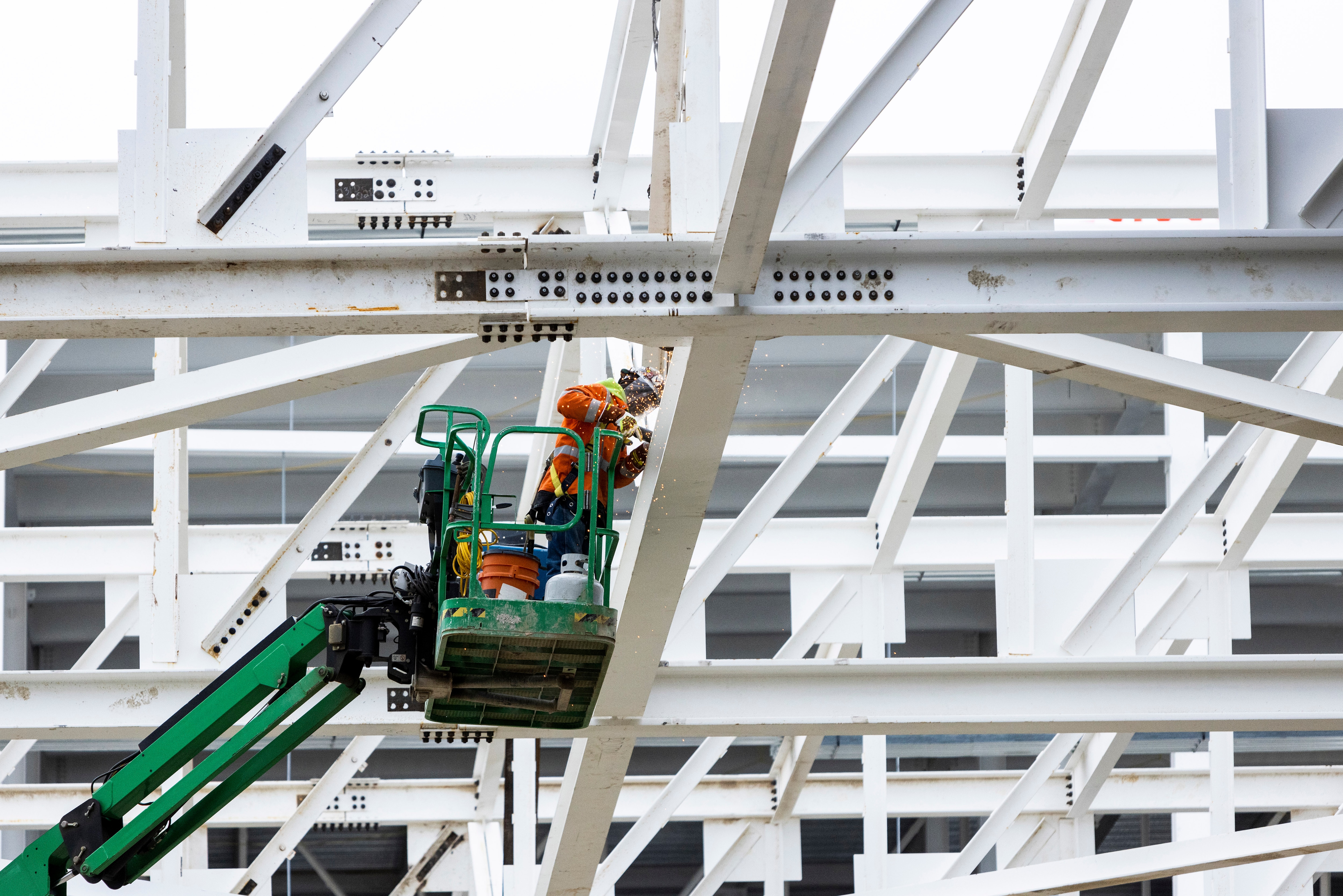 A construction worker in a crane bucket.
